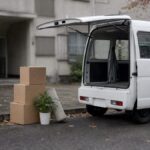 引っ越し先に停まる軽バンと段ボール